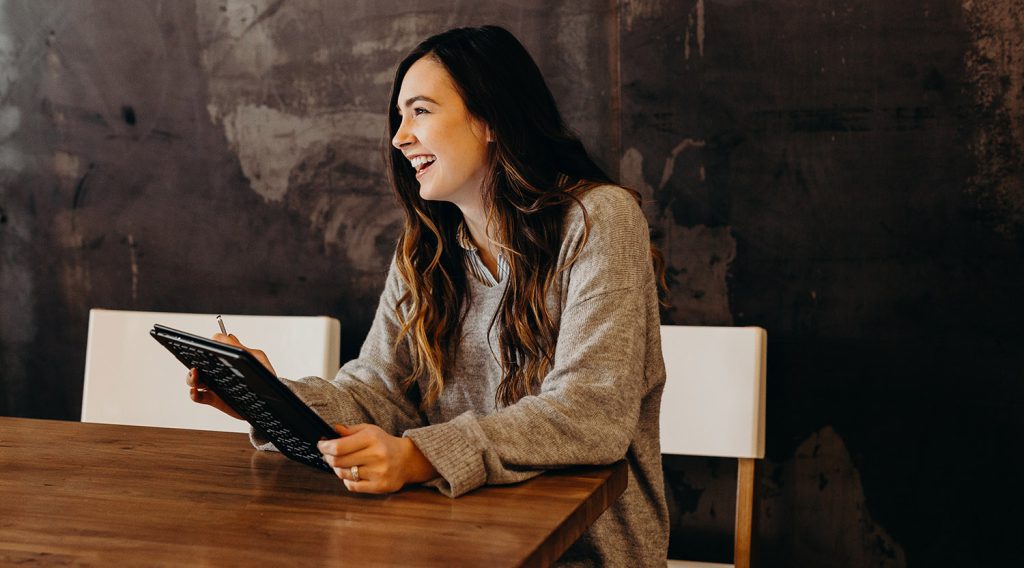 Woman smiling with notepad and paper