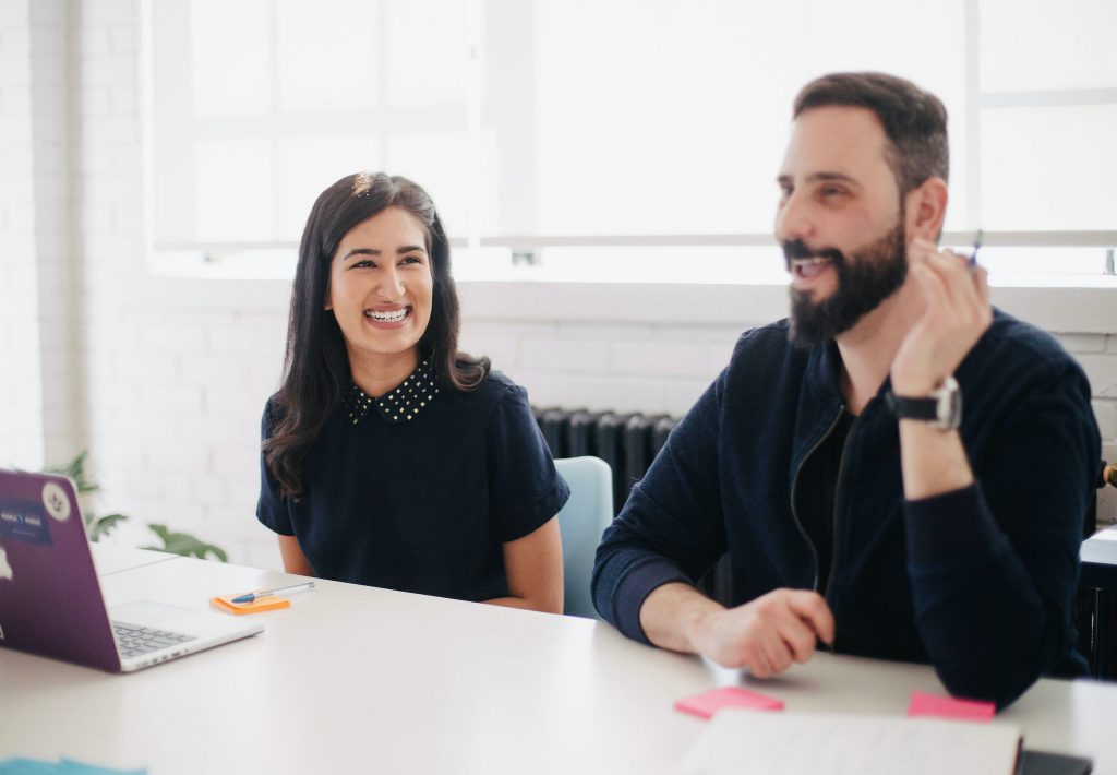 Two colleagues smiling at desk